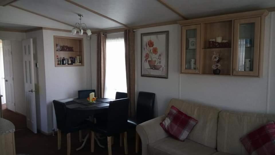 a living room with a couch and a dining room table at ChapmanHolidayLets Cayton Bay in Cayton