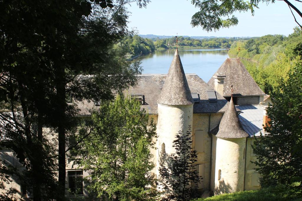 un vieux château avec un lac en arrière-plan dans l'établissement Château de Courtebotte, à Saint-Jean-de-Blaignac
