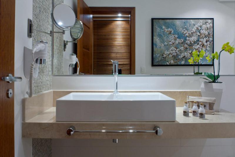 y baño con lavabo blanco y espejo. en Abayomi Hotel en Ilhabela