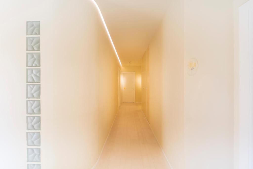 a hallway with a white wall and a white door at Fonda Llabres Boutique in Alcudia