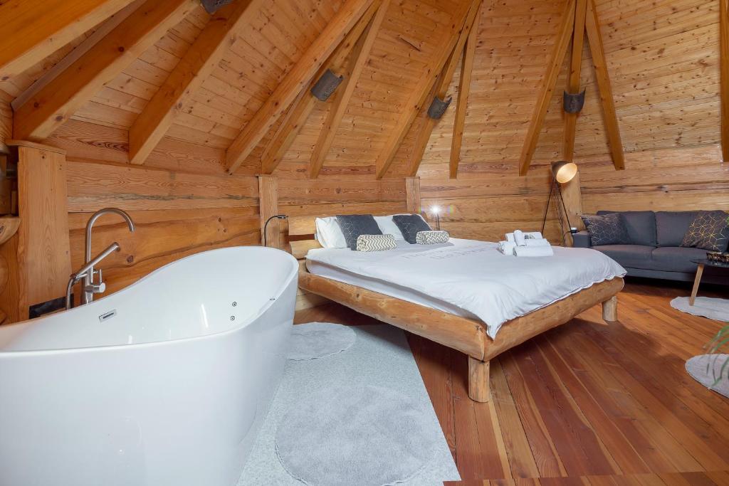 Schlafzimmer mit einem Bett und einer Badewanne in der Unterkunft Wellness hiska Izabela in Križevci pri Ljutomeru