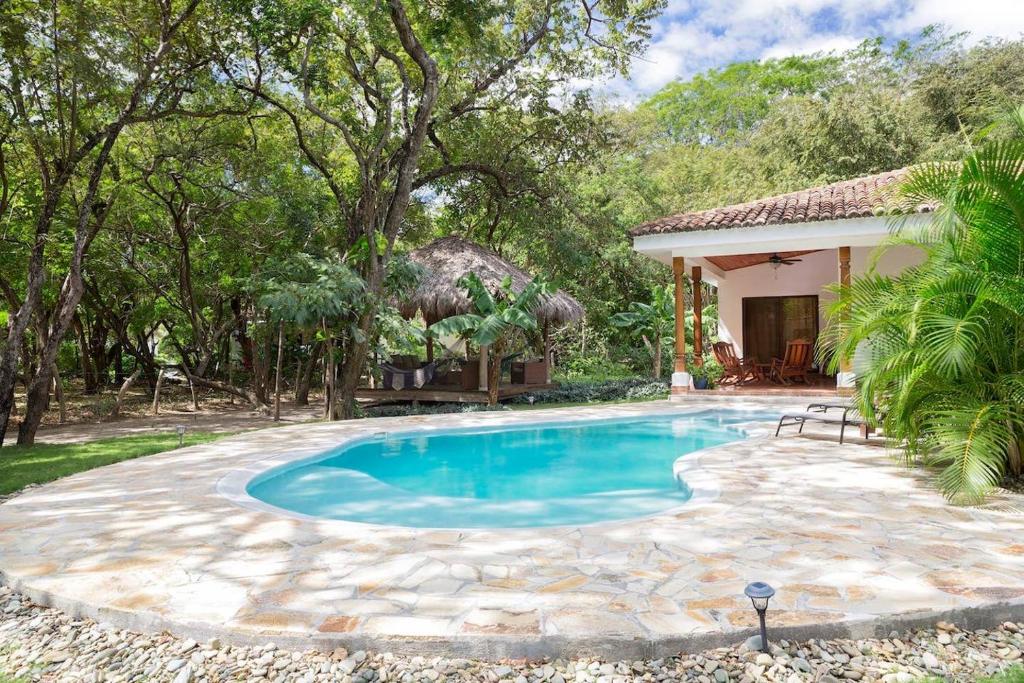 ein Schwimmbad in einem Hof neben einem Haus in der Unterkunft Zen Casita near Playa Colorado! in Tola