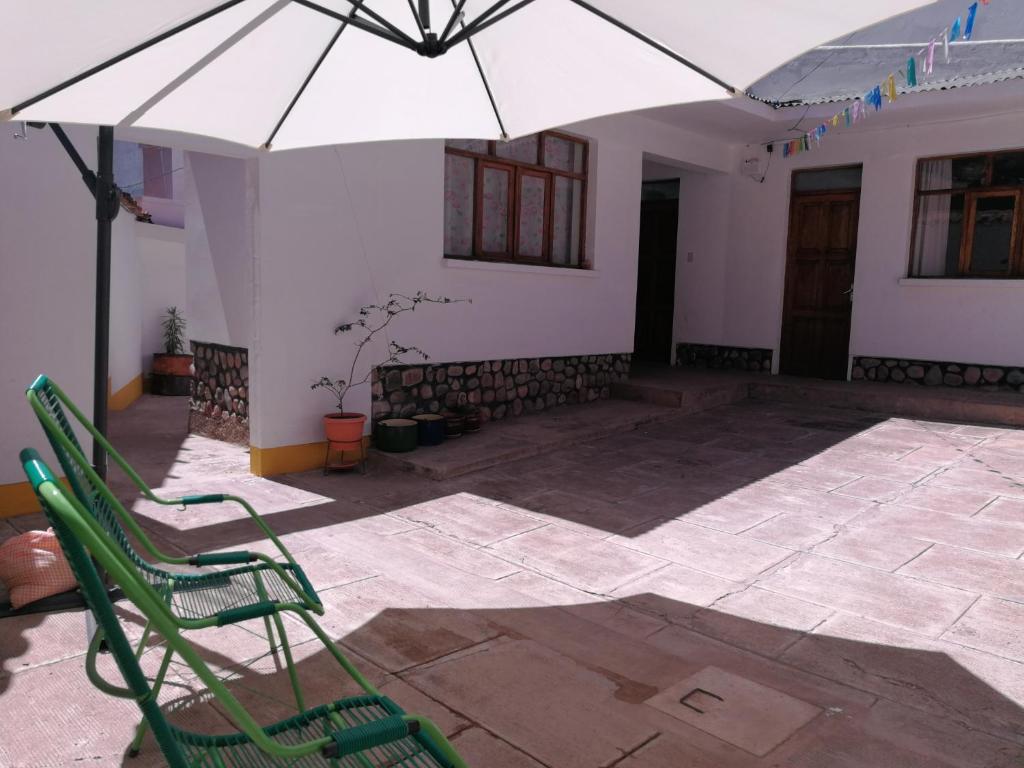 a patio with two chairs and an umbrella at Charlies Place in Sucre