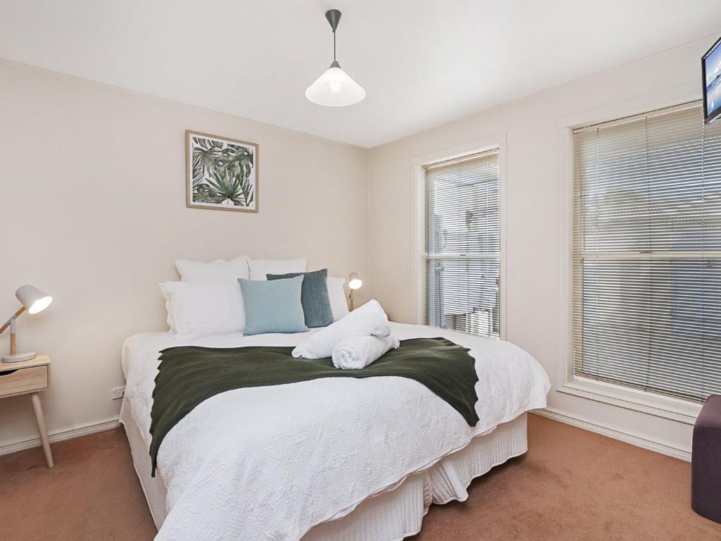 a bedroom with a large white bed and a window at Moyne Views 2 in Port Fairy