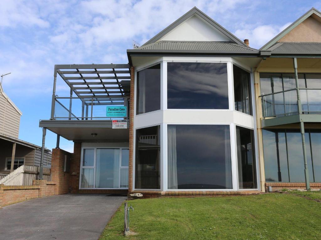 a house with large glass windows on the side of it at Paradise Cove in Port Fairy