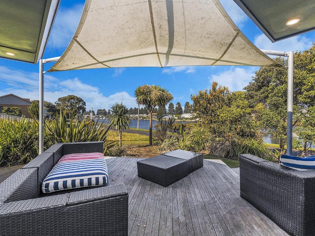 a patio with a couch and an umbrella at Rossleague House in Port Fairy