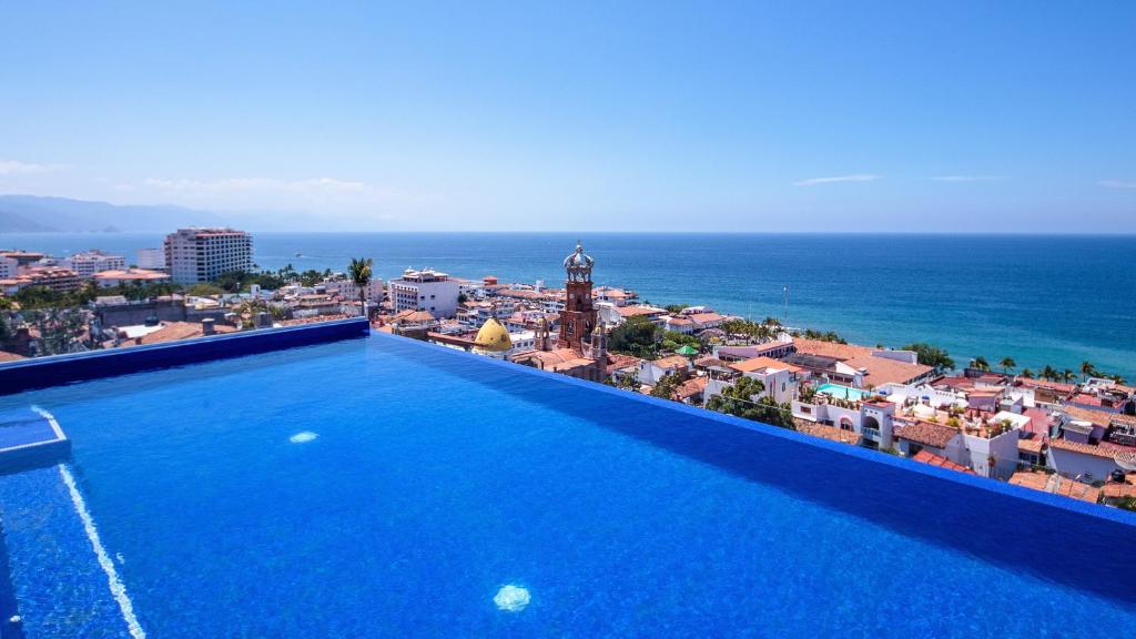 a swimming pool with a view of a city at NISE in Puerto Vallarta