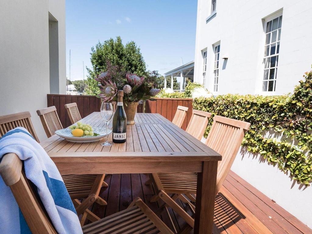 una mesa de madera con un bol de fruta en la terraza en Spinnakers Waterfront, en Port Fairy