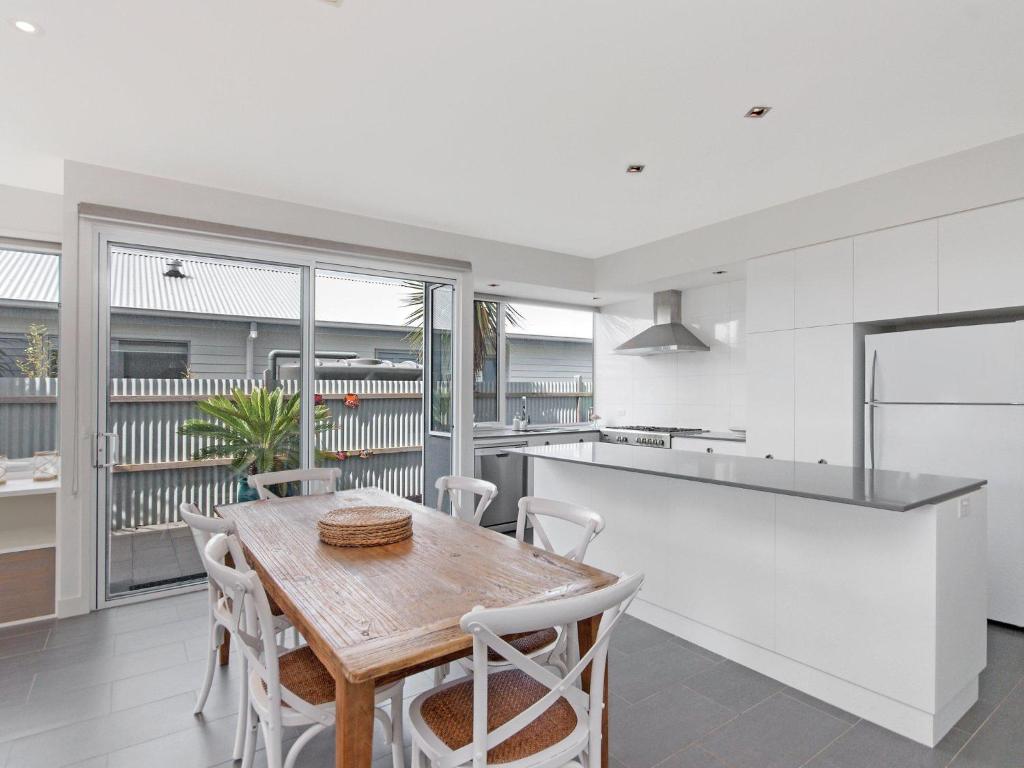 a kitchen and dining room with a wooden table and chairs at The Craic in Port Fairy