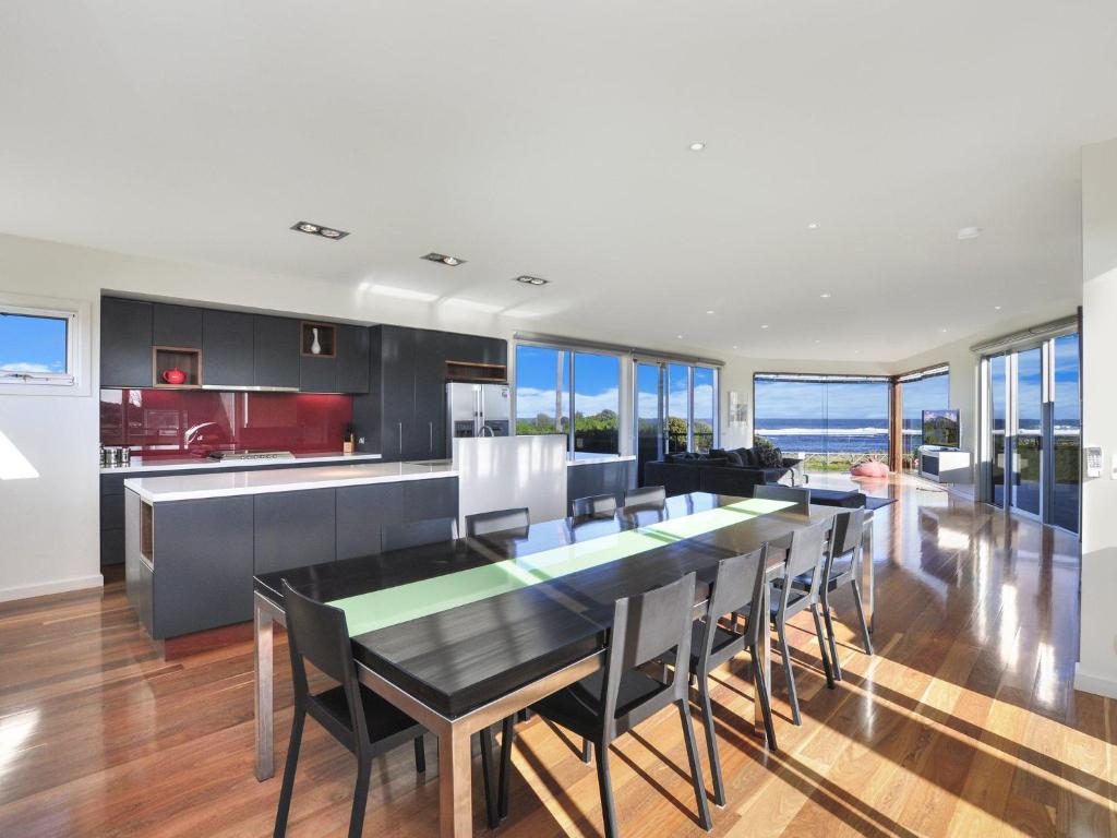 a kitchen and dining room with a table and chairs at Whispers in Port Fairy