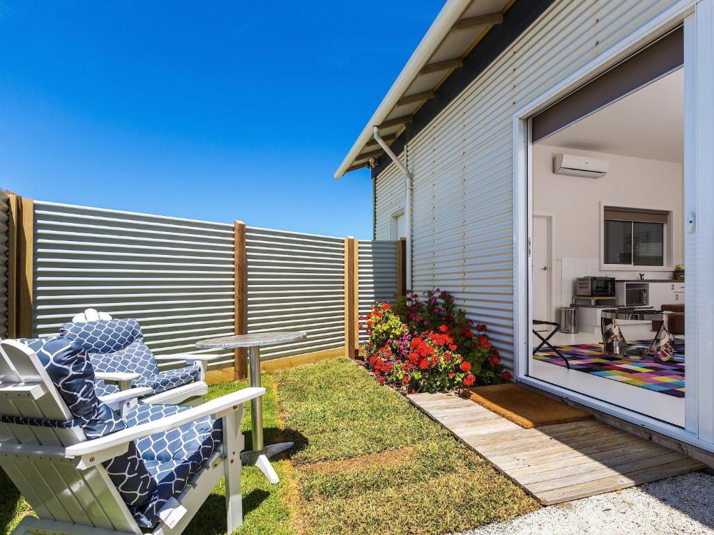 a patio with a chair and a table and a fence at Wytonia Cabana in Port Fairy