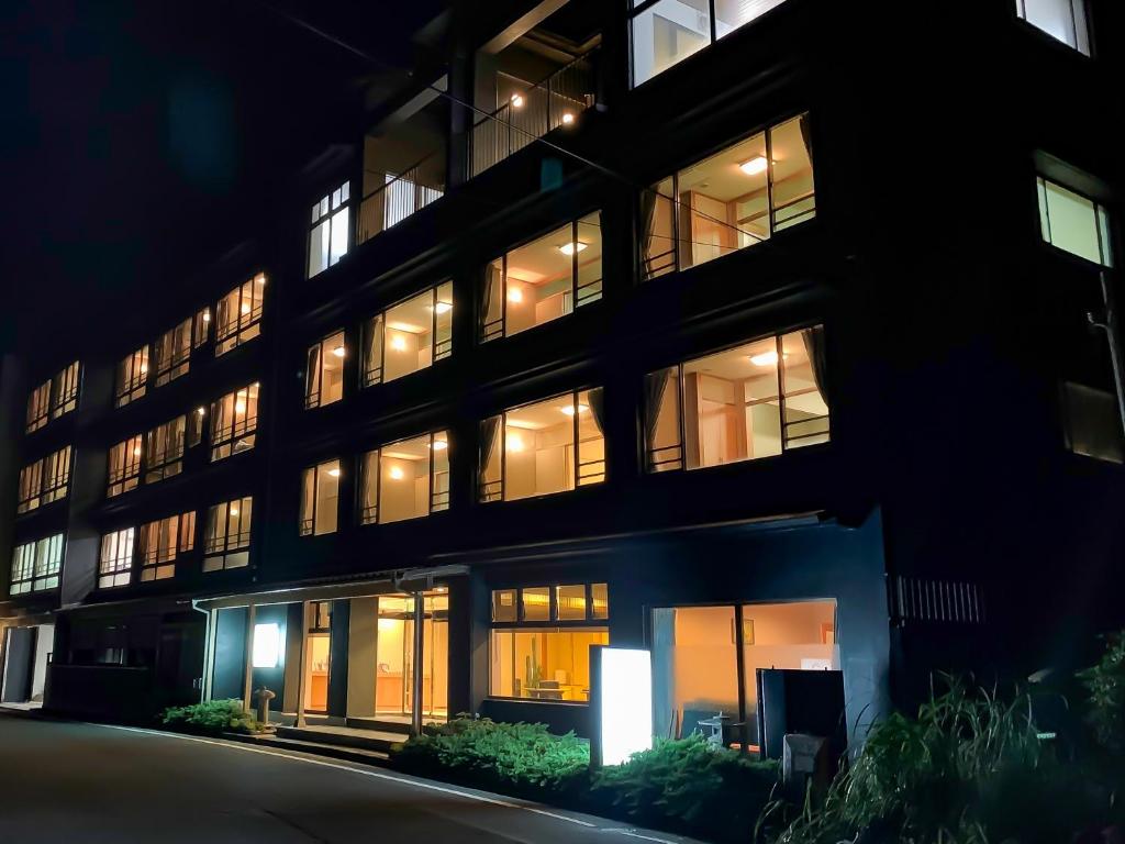 a large building with lit up windows at night at HOTEL&RESORT Izu no Ne in Higashiizu