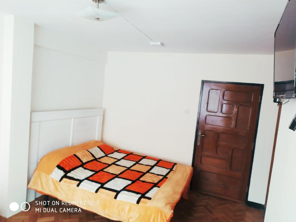 Habitación pequeña con cama y puerta en Sunny and private 2, en La Paz