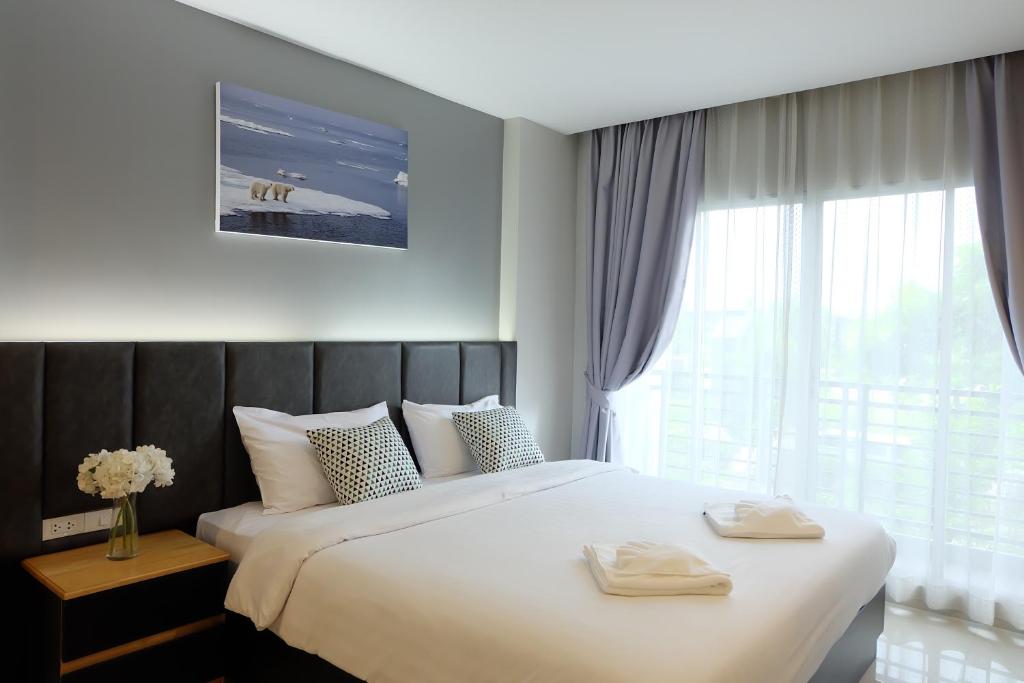 sypialnia z dużym łóżkiem z dwoma ręcznikami w obiekcie Interpark Hotel & Residence, Eastern Seaboard Rayong w mieście Ban Phan Sadet Nok