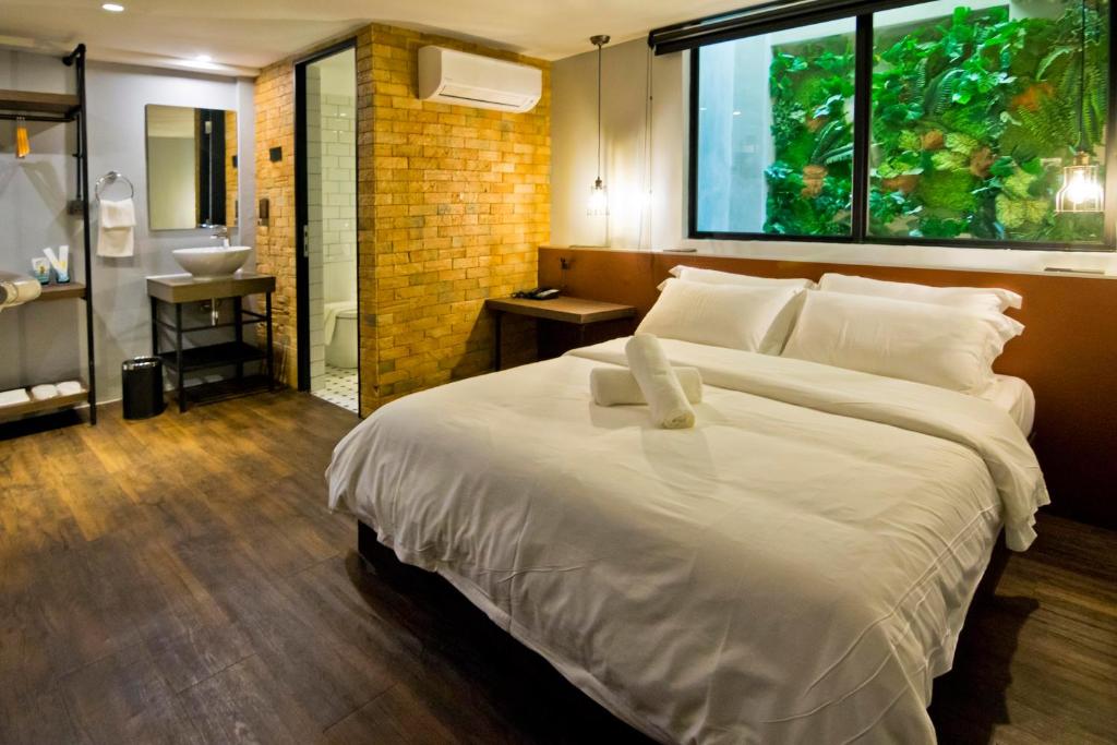 Postel nebo postele na pokoji v ubytování JonkeRED Heritage Hotel