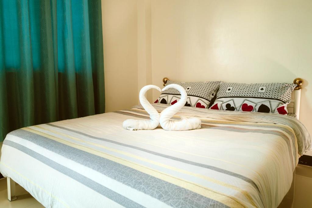 Dois cisnes brancos sentados numa cama em Diane Sunshine Villa em Panglao