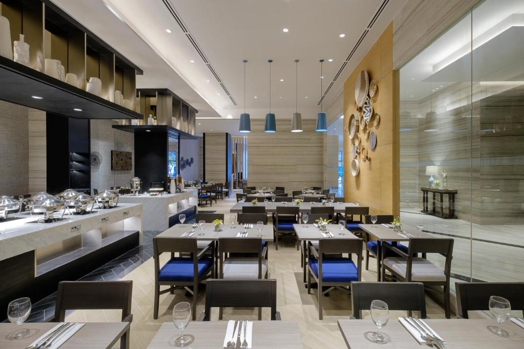 um restaurante com mesas e cadeiras e um bar em Savoy Hotel Mactan em Mactan