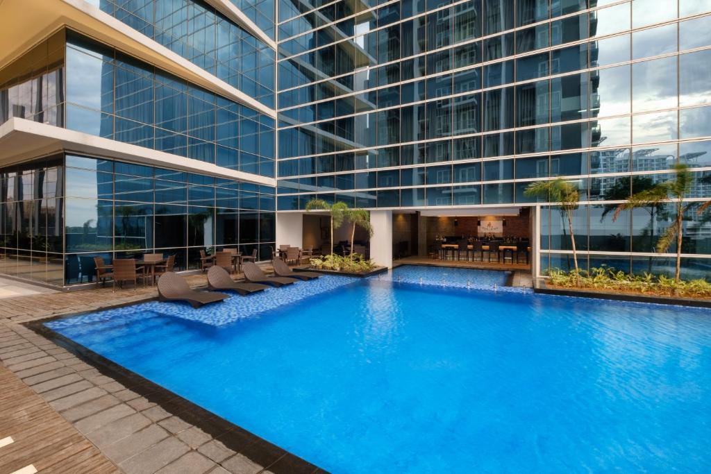 a large building with a large pool in front of it at Savoy Hotel Mactan in Mactan