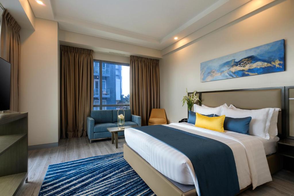um quarto de hotel com uma cama e uma TV em Savoy Hotel Mactan em Mactan