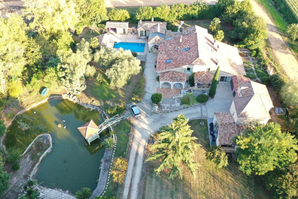 an aerial view of a large house with a pond at Le Bois de Montpouillan in Montpouillan
