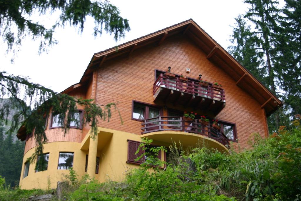 a house with a balcony on the side of it at Vila Gal in Lacu Rosu