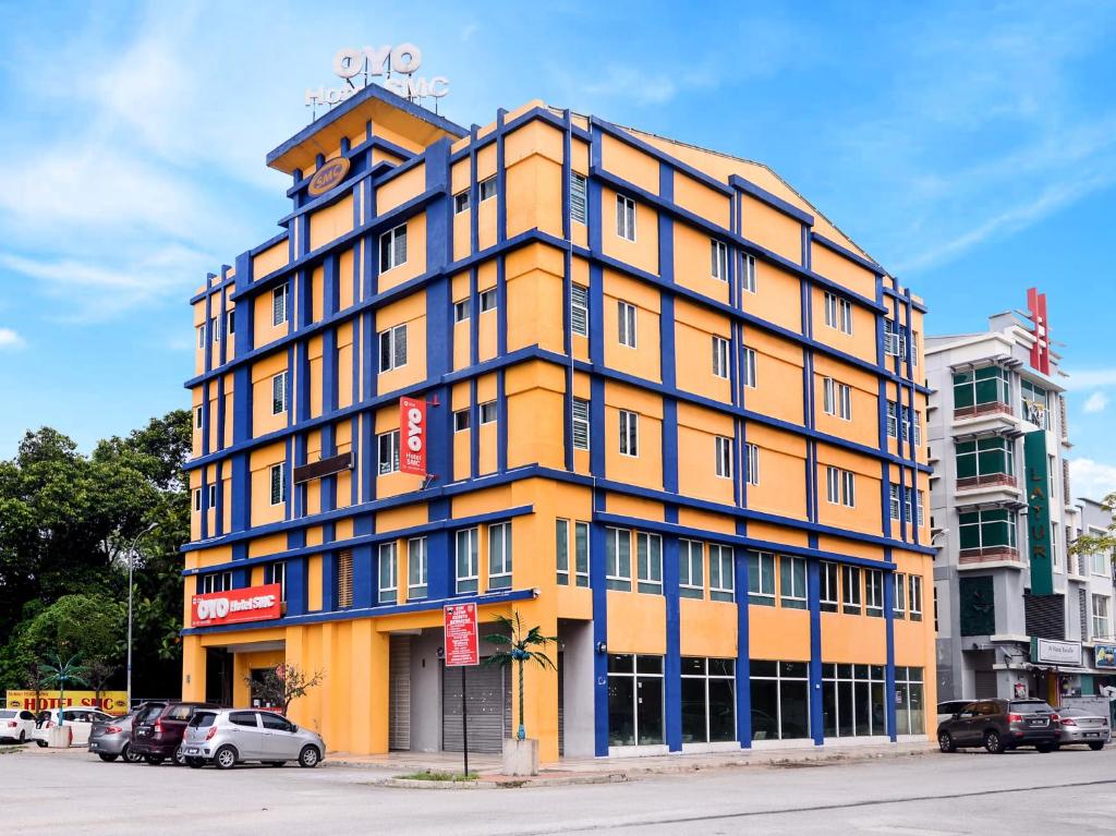 um edifício amarelo com acabamento azul numa rua em Super OYO 258 Hotel SMC Alam Avenue em Shah Alam