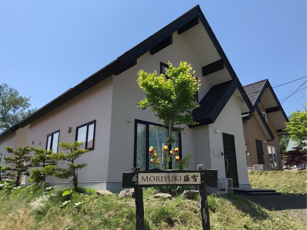 ein Haus mit einem Schild davor in der Unterkunft Moriyuki in Furano