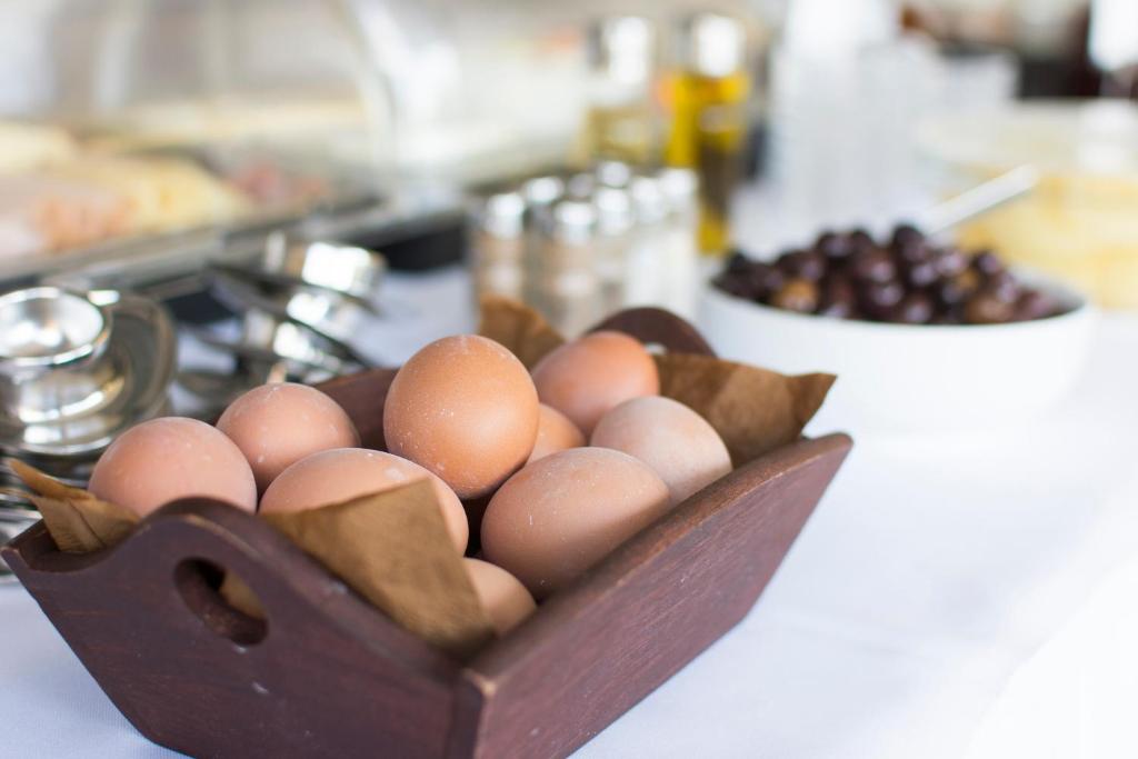 a bunch of eggs in a wooden bowl on a counter at Riviera Perdika Hotel in Perdika