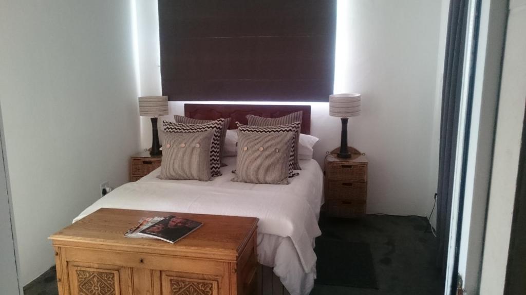 - une chambre avec un lit avec des oreillers et une table dans l'établissement 4 On Braemar - Flat B, à Nottingham Road