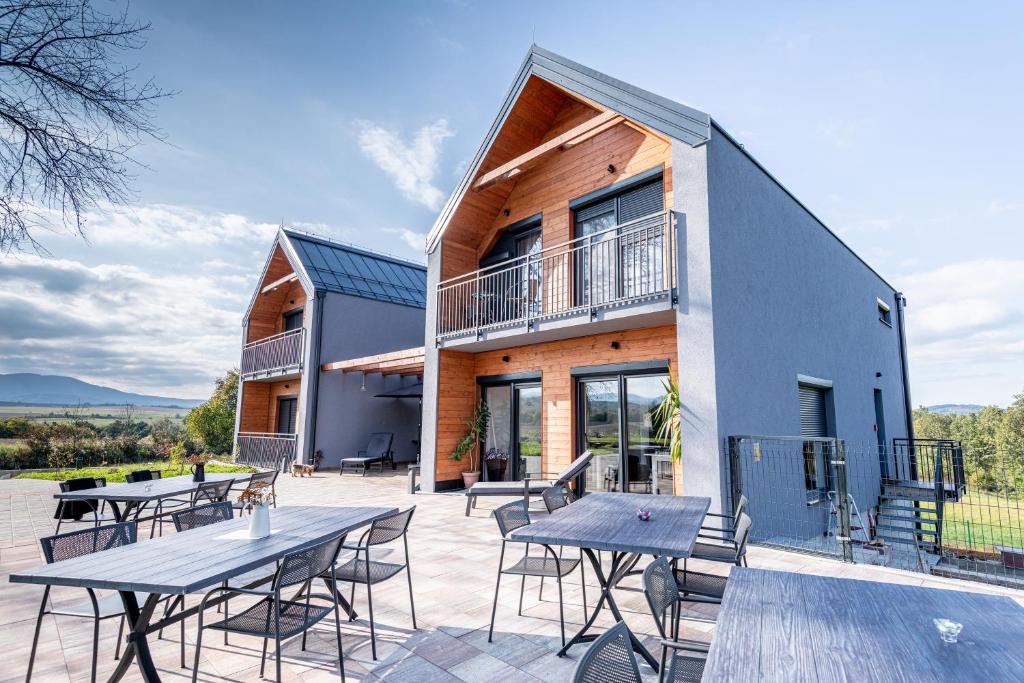 a house with a patio with tables and chairs at B&B Villa Dolina Plitvice in Plitvička Jezera