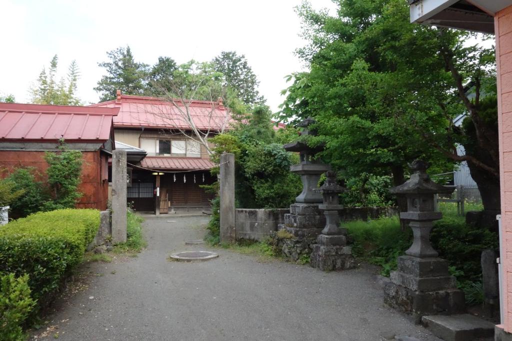 una casa antigua con una puerta y un edificio en OSHI-KIKUYABO Mt-Fuji Historic Inn en Fujiyoshida