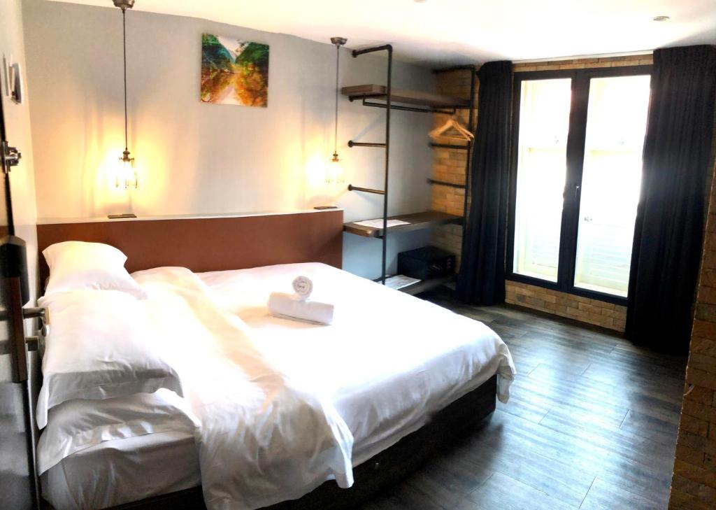 Postel nebo postele na pokoji v ubytování JonkeRED Heritage Hotel