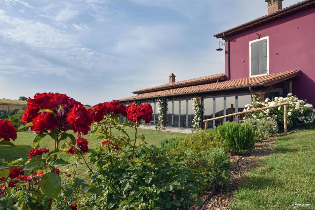 una casa con flores rojas delante de ella en Agriturismo Re Tarquinio, en Tuscania