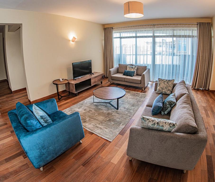 a living room with two couches and a tv at Valley Arcade Towers - Kilimani in Nairobi