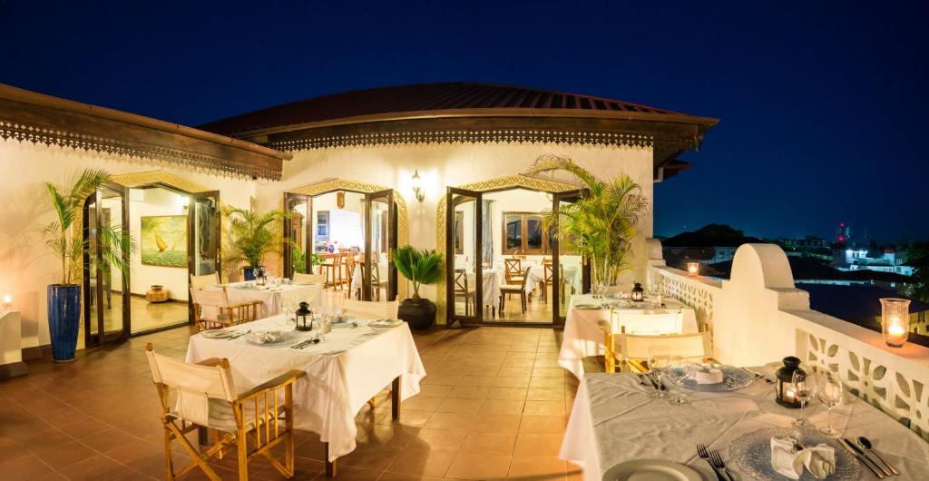 a restaurant with tables on a balcony at night at Kisiwa House in Zanzibar City