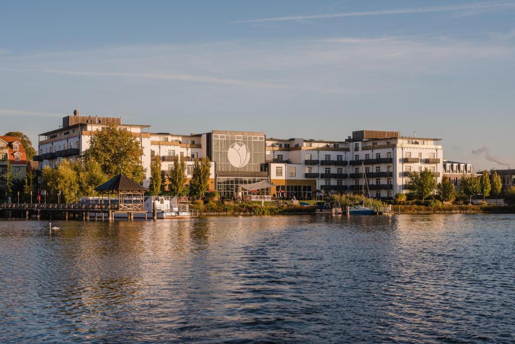 vista su un grande bacino idrico con edifici di Resort Mark Brandenburg & Fontane Therme a Neuruppin