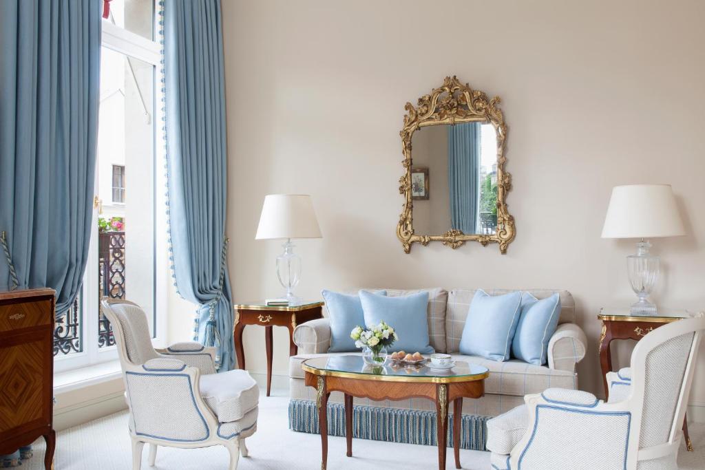 a living room with a couch and chairs and a mirror at Le Bristol Paris - an Oetker Collection Hotel in Paris