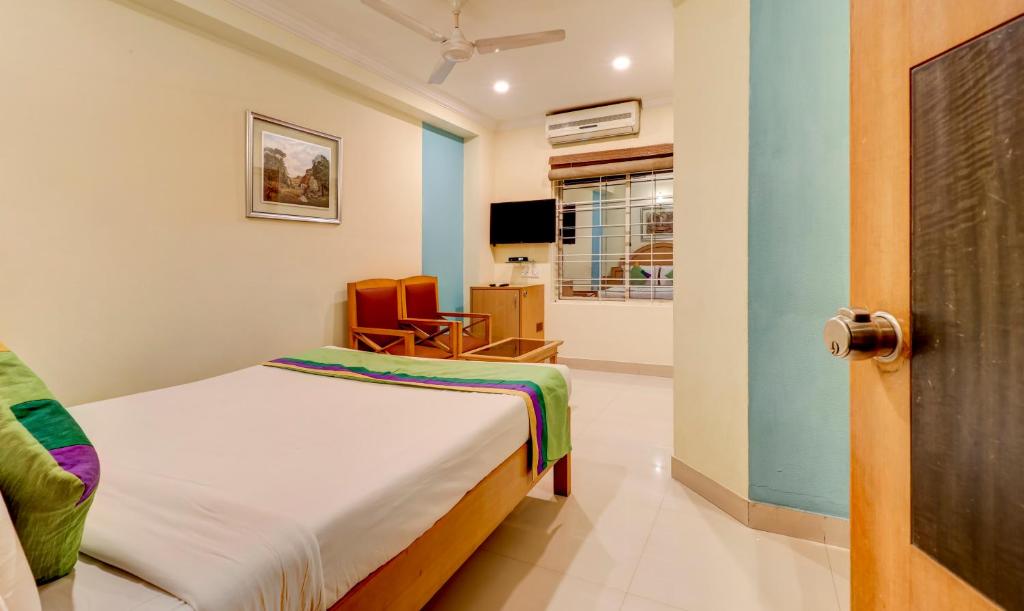 a small bedroom with a bed and a chair at Treebo Terminus, Koramangala 5th Block in Bangalore