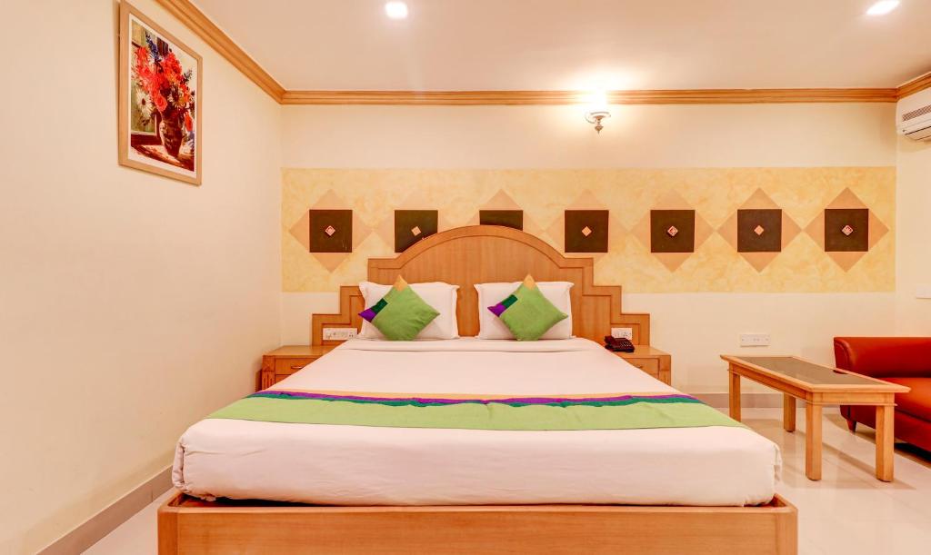a bedroom with a bed and a red couch at Treebo Terminus, Koramangala 5th Block in Bangalore