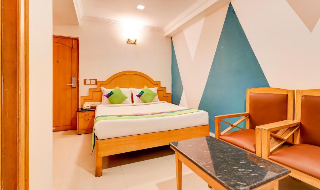 a hotel room with a bed and a chair at Treebo Trend Terminus Koramangala 5th Block in Bangalore