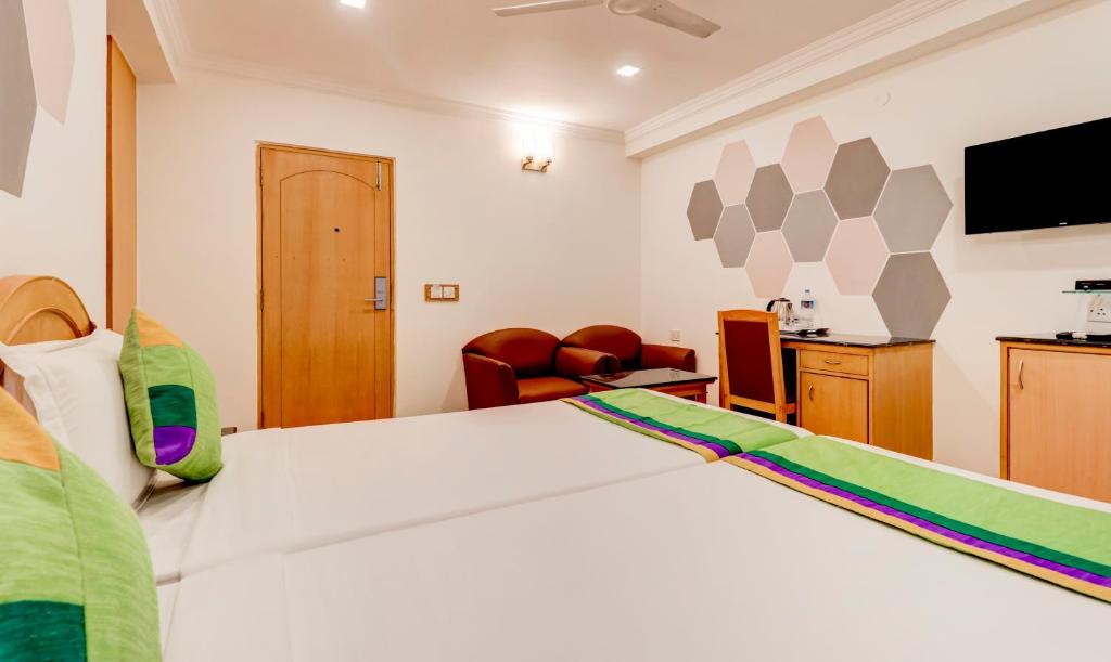 a bedroom with a large bed and a tv at Treebo Terminus, Koramangala 5th Block in Bangalore