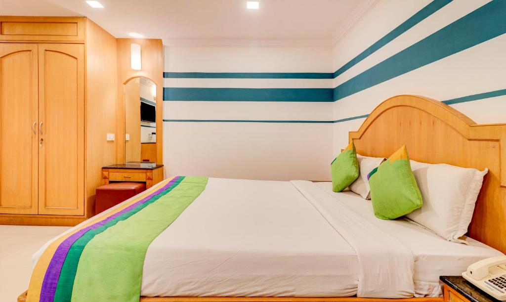 a bedroom with a bed with blue and green stripes at Treebo Terminus, Koramangala 5th Block in Bangalore