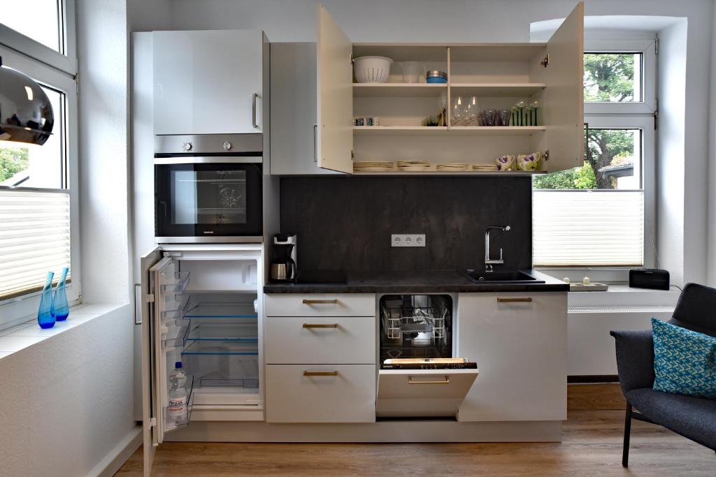 a kitchen with white cabinets and a microwave at Ferienwohnung am Wall in Soest