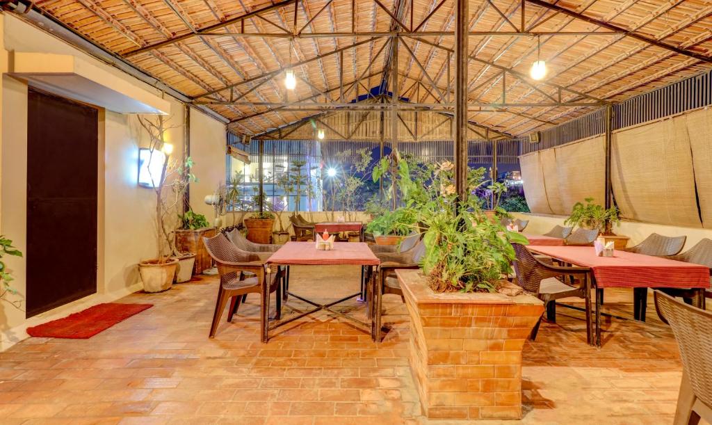 a restaurant with tables and chairs in a room at Treebo Terminus, Koramangala 5th Block in Bangalore