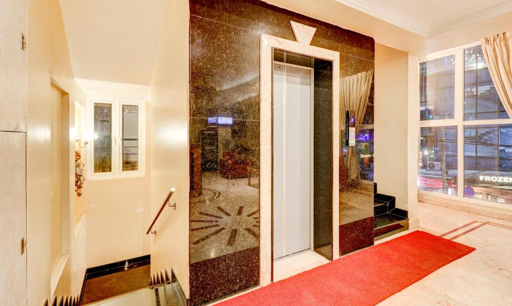 a hallway with a door with a red rug at Treebo Terminus, Koramangala 5th Block in Bangalore