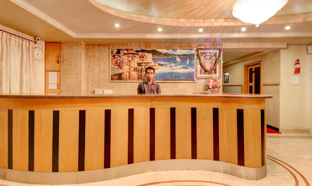 a man standing at a bar in a room at Treebo Terminus, Koramangala 5th Block in Bangalore