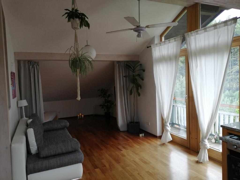 a living room with a couch and a ceiling fan at ***den Bergen ganz nah*** in Brannenburg