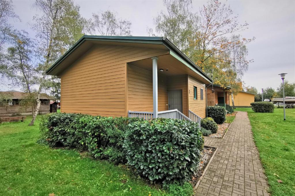 a small house with a brick sidewalk in front of it at Centrum Żeglarskie Domki Kempingowe in Szczecin