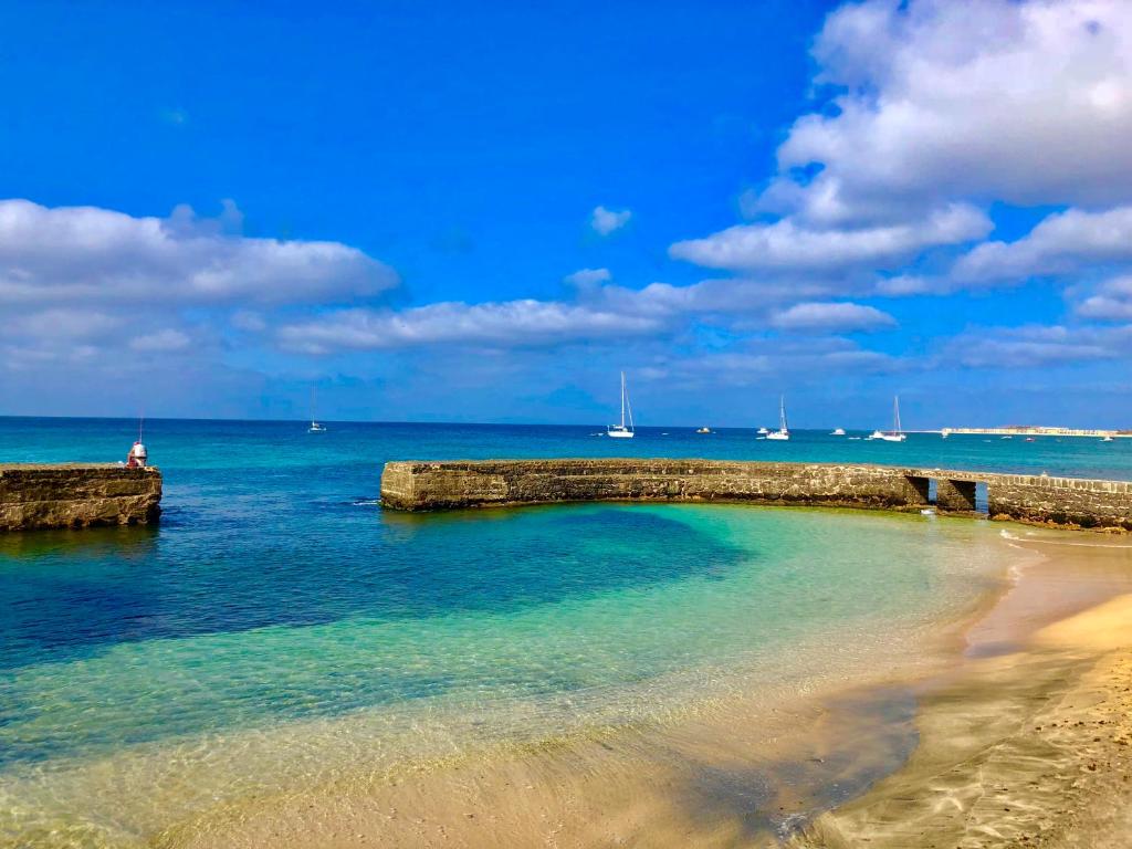 a beach with a rock wall in the water at Sal&Love apt in Porto Antigo in Santa Maria