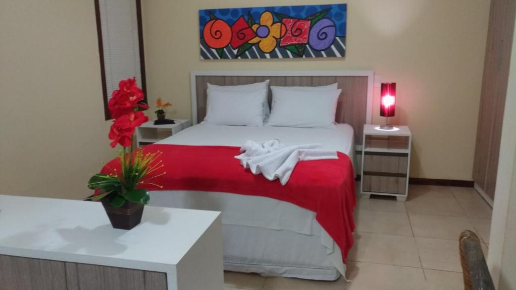 1 dormitorio con 1 cama con manta roja en Solar Pipa Praia Flats en Pipa